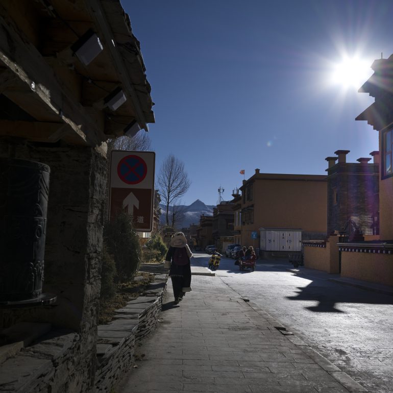 A Kham solitary walk through Litang’s stone streets, bathed in the golden light of the high plateau sun.