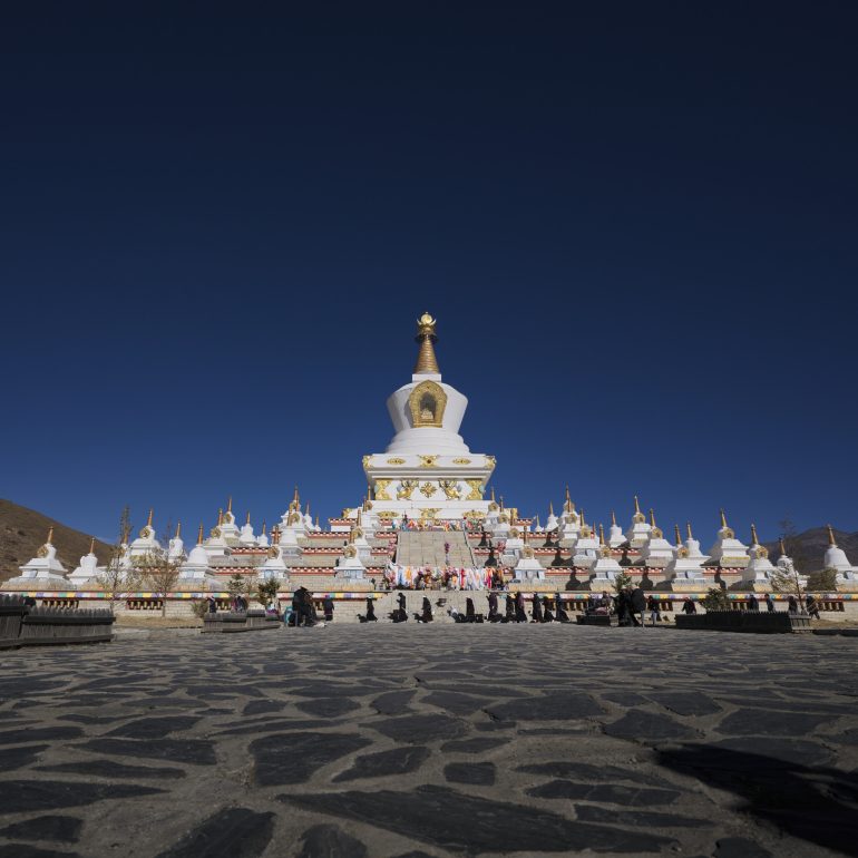 Under the azure sky, the majestic white stupa stands as a spiritual beacon in LiTang.