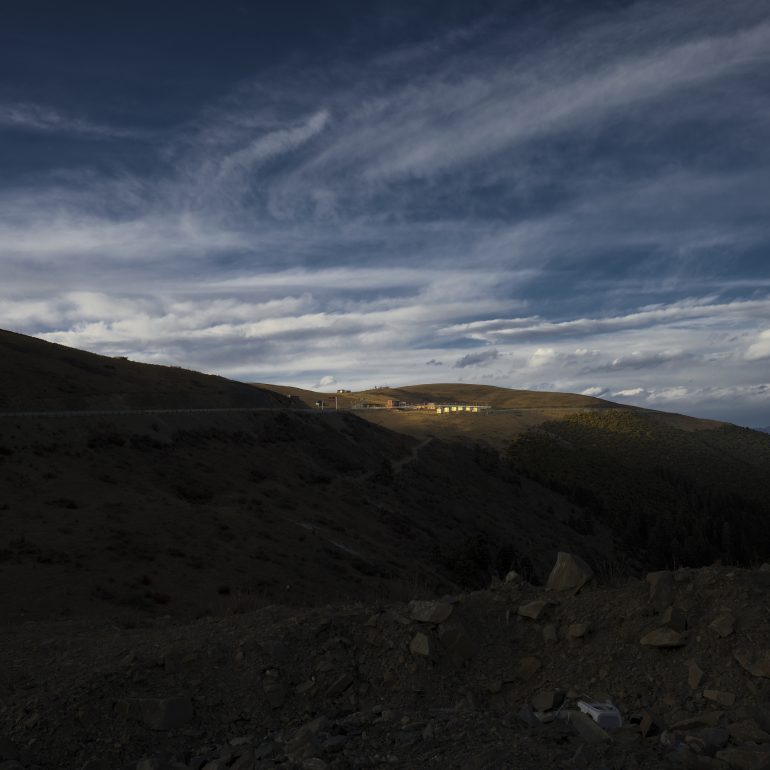 Winding roads cut through the hills under a vast, cloud-streaked sky at Zhegu Mountain.