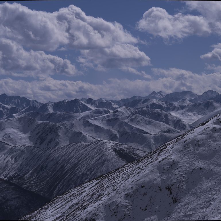 Layered snow peaks like waves, cloud shadows glide over ridges—ZiMei Pass unfolds a winter masterpiece.